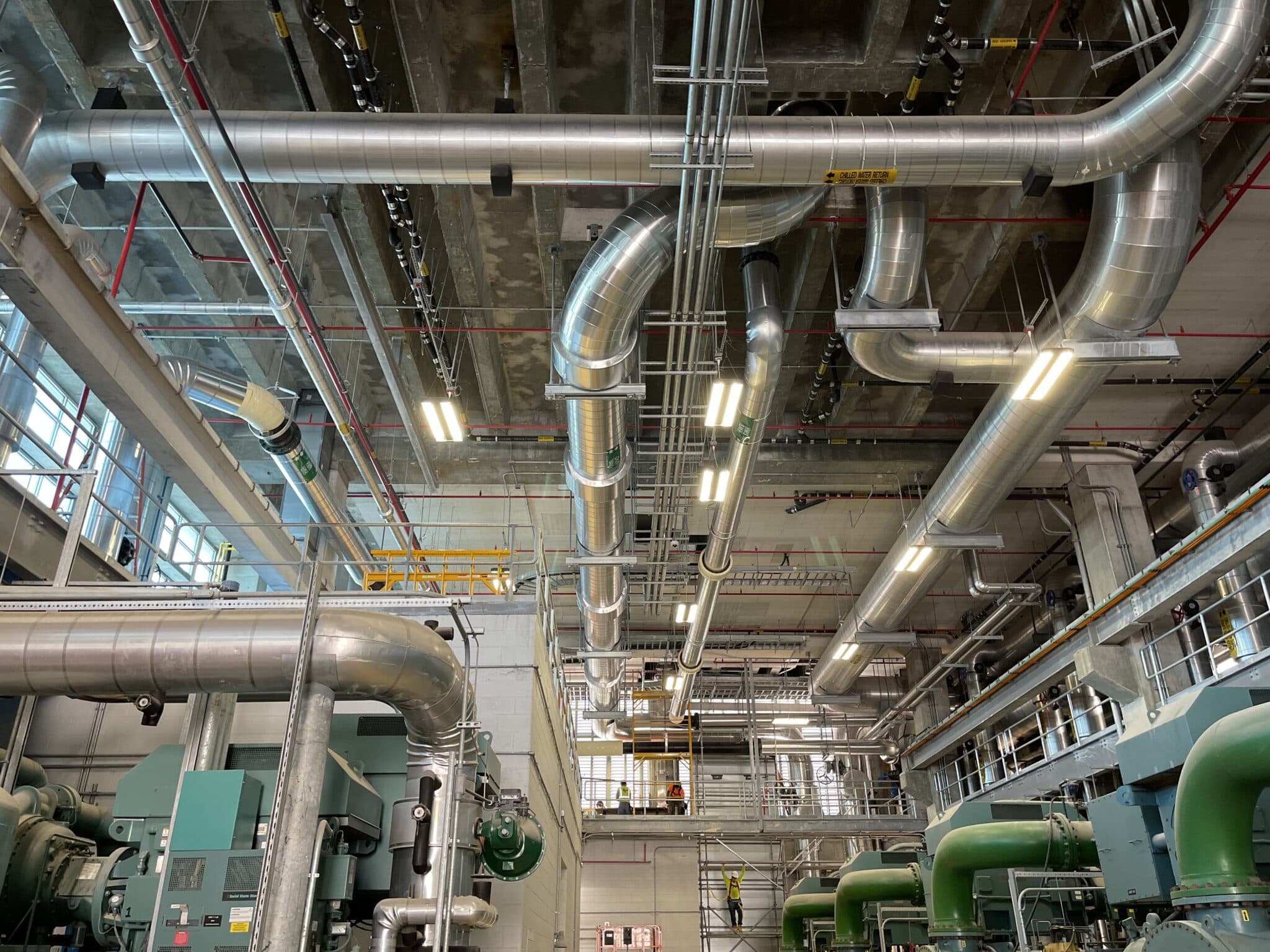 Commercial mechanical room with ductwork, piping, and chiller plant