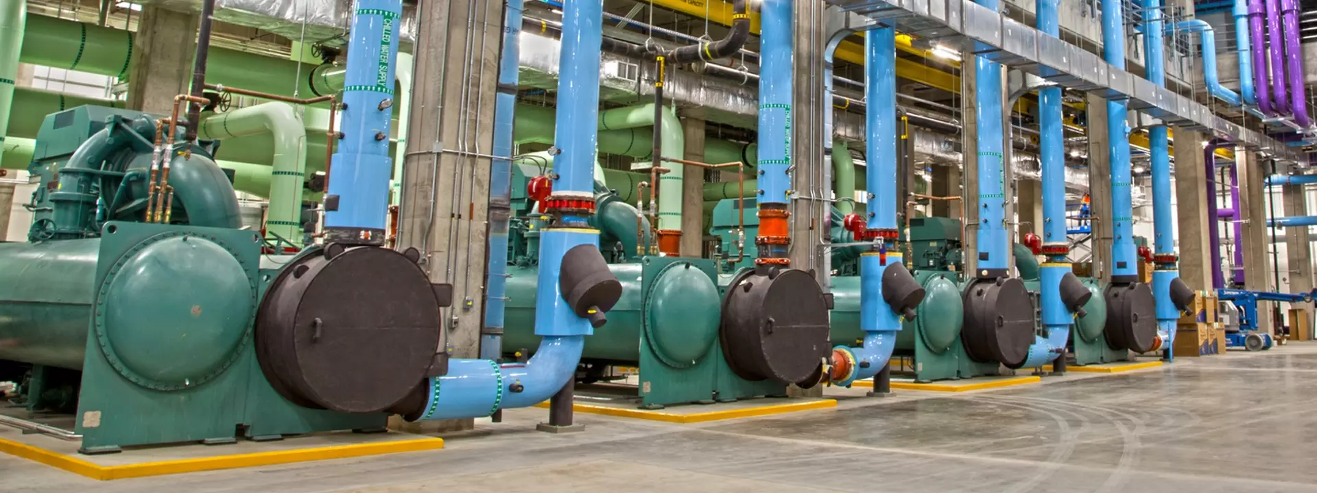 Commercial mechanical room with ductwork, piping, and chiller plant