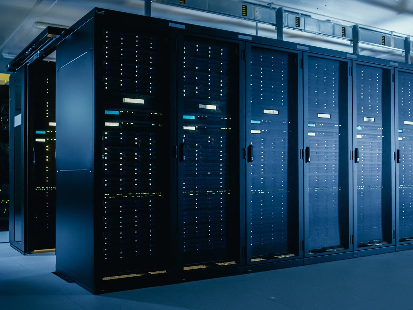 Data center server room with rows of black server racks and blue lighting